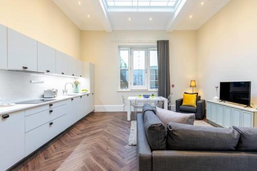ein Wohnzimmer mit einem Sofa und einer Küche in der Unterkunft 2-BR apartment for 6 in Covent Garden with ac in London