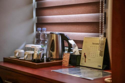 a counter with a tea kettle and other items on it at Shine BnB in Tjiandjur