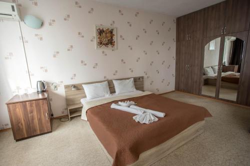 a bedroom with a bed with two white towels on it at Park Hotel Ivailo in Veliko Tŭrnovo