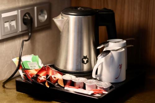 a coffee pot and cups on a tray with a mixer at Landgoed Oud Poelgeest - Leiden in Oegstgeest