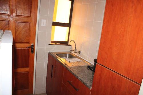 a small kitchen with a sink and a mirror at Boikhutsong Bed & Breakfast in Maseru
