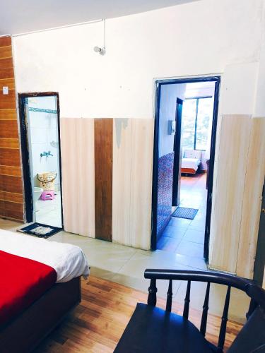 a room with a bed and a hallway with a door at HOTEL HOLIDAY PLAZA DALHOUSIE - Near Ghandhi Chowk Mall Road in Dalhousie