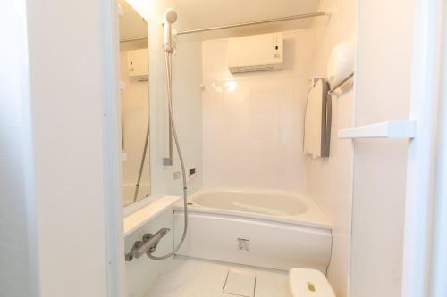 a bathroom with a tub and a sink and a toilet at OSAKA NOSE Farmer's Guest House　YASUDA FARM in Nose