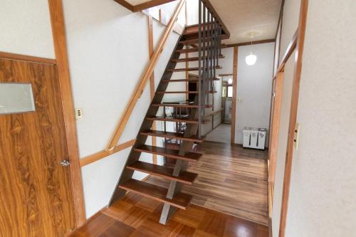 a wooden spiral staircase in a home with wooden floors at OSAKA NOSE Farmer's Guest House　YASUDA FARM in Nose