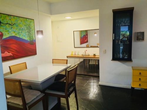 uma sala de jantar com uma mesa e cadeiras e um quadro em Plaza Elysees 202 no Rio de Janeiro