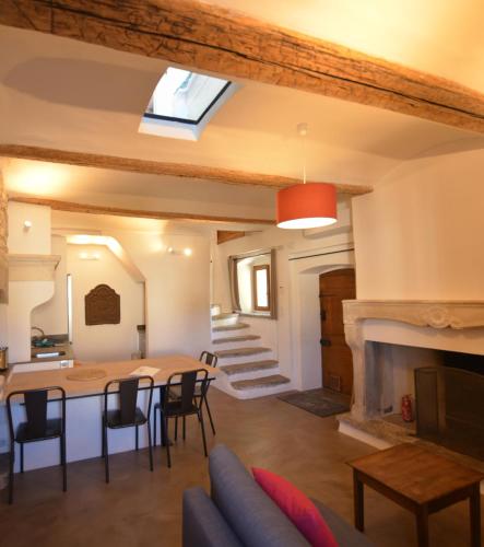 un salon avec une table et une cheminée dans l'établissement Le Repaire du Pic, gîte de charme 3 étoiles, à Notre-Dame-de-Londres