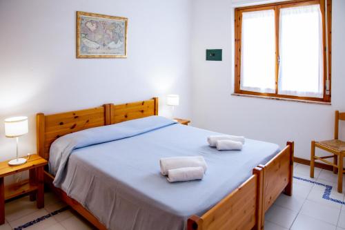 ein Schlafzimmer mit einem Bett mit zwei Handtüchern darauf in der Unterkunft Residence Buganvillea in Alghero