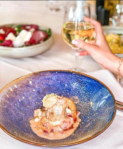 a plate of food on a table with a glass of wine at Hotel Majestic in Durrës