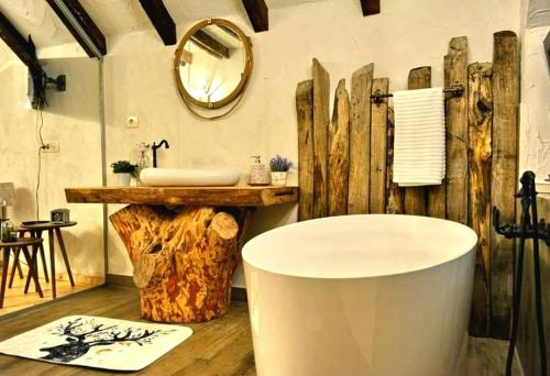 a bathroom with a large tub and a sink at Cuibul Braneanului in Bran