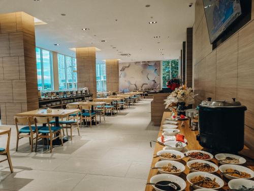 a dining room with tables and plates of food at ASTON Nagoya City Hotel in Batam Center