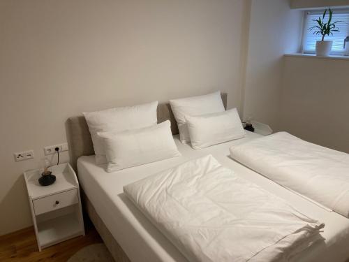 - une chambre avec 2 lits avec des draps blancs et une fenêtre dans l'établissement Villa Emilia Rottweil, à Rottweil