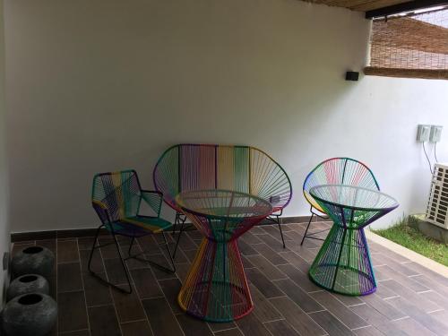 four colorful chairs and a table and two chairs at Villa Paraiso do Mar in Jacó