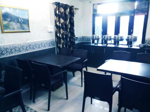 a dining room with black tables and chairs at HOTEL HOLIDAY PLAZA DALHOUSIE - Near Ghandhi Chowk Mall Road in Dalhousie