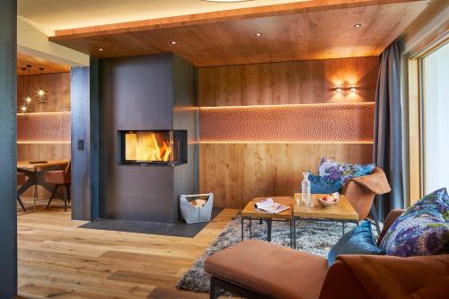 a living room with a couch and a fireplace at Sporthotel Ellmau in Tirol in Ellmau