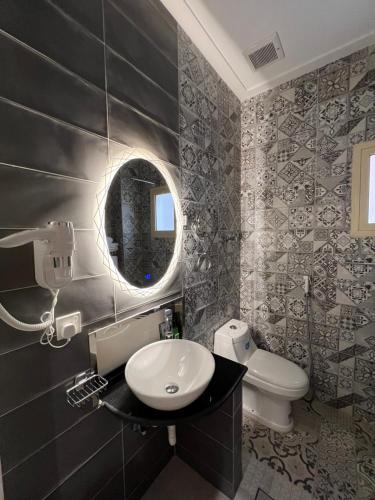 uma casa de banho com um lavatório, um WC e um espelho. em فندق الليالي الحالمة em Medina