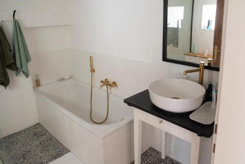 a white bathroom with a sink and a tub and a mirror at dasFritsch-Historisches Weinbauernhaus im Grünen in Klein-Reinprechtsdorf