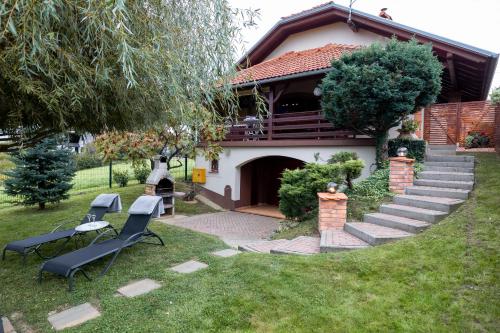 a house with two chairs and a table in the yard at Holiday Home Vitis in Selnica