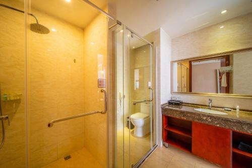 a bathroom with a shower and a sink and a toilet at Changsha Jiaxing Inn in Changsha
