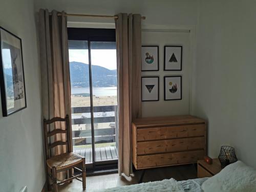 une chambre avec un lit et une fenêtre avec vue dans l'établissement Duplex avec vue lac, résidence la Singlantane, aux Angles