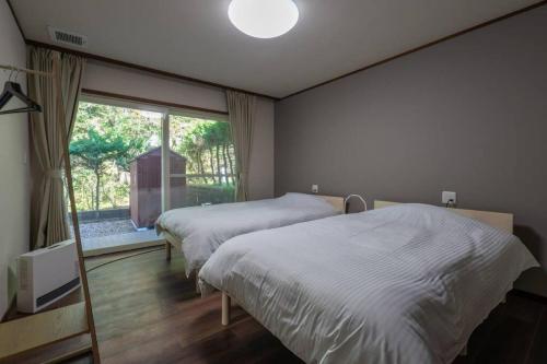 A bed or beds in a room at ペットと泊まれる一日一組限定の貸切ヴィラ　ウェルシー山中湖