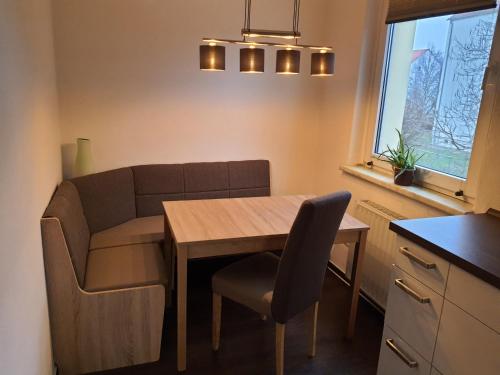 uma pequena cozinha com uma mesa e um sofá em Ferienwohnung Geiseltalsee em Braunsbedra