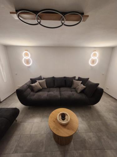 a living room with a black couch and a table at Apartment am Südhang 2 in Dinkelsbühl