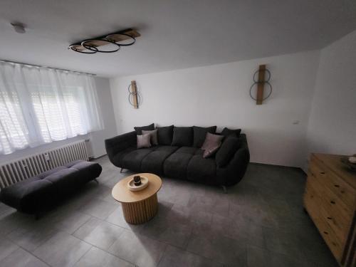 a living room with a black couch and a table at Apartment am Südhang 2 in Dinkelsbühl