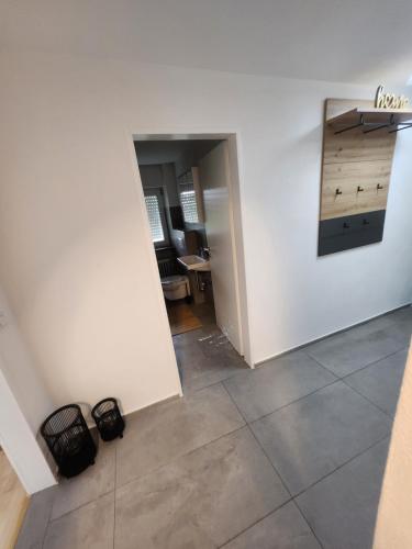 an empty room with a white wall and a tile floor at Apartment am Südhang 2 in Dinkelsbühl
