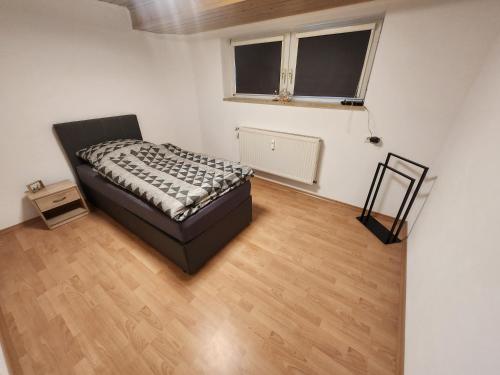 a bedroom with a bed and a wooden floor at Apartment am Südhang 2 in Dinkelsbühl