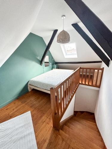 ブリーヴ・ラ・ガイヤルドにあるCharmant duplex en centre-villeのベッドと階段が備わる小さな客室です。