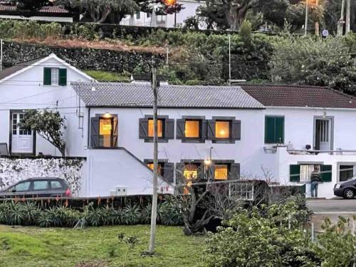 a white house with a car parked in front of it at Casa da Esquila Ilha do Pico 1 in São Roque do Pico