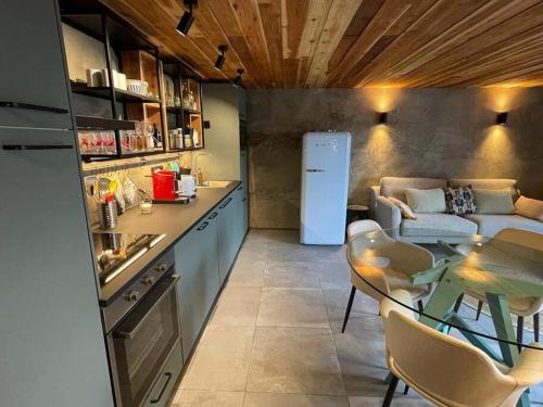 a kitchen and living room with a table and a couch at Casa da Esquila Ilha do Pico 1 in São Roque do Pico