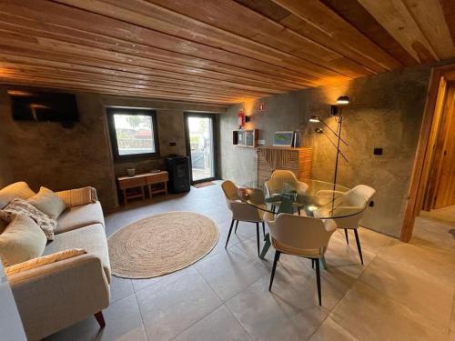a living room with a couch and a table and chairs at Casa da Esquila Ilha do Pico 1 in São Roque do Pico