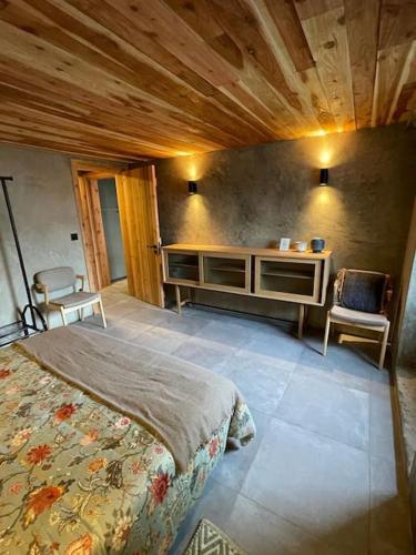 a bedroom with a bed and a table and chairs at Casa da Esquila Ilha do Pico 1 in São Roque do Pico