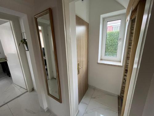 a hallway with a mirror and a window at lovely house for relaxing trips in Vienna