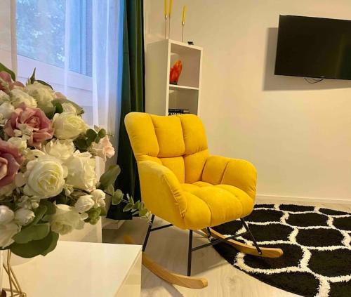 a yellow chair in a room with a vase of flowers at Gartenparadies Ferienhaus in Singen