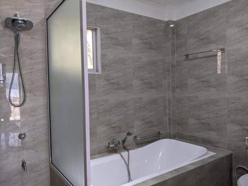a bathroom with a bath tub and a shower at Lopez Beach Resort in Sipalay