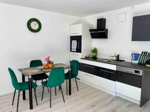 a kitchen with a table and some green chairs at Gartenparadies Ferienhaus in Singen