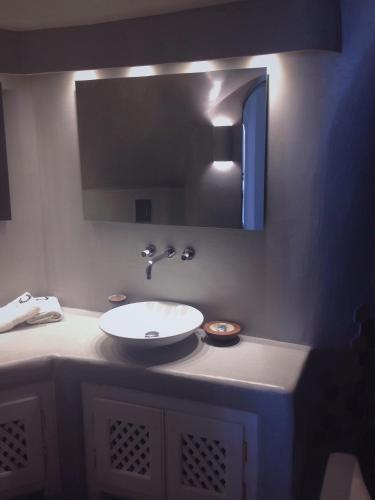 a bathroom with a sink and a mirror at Altana Cliffside Villas in Imerovigli
