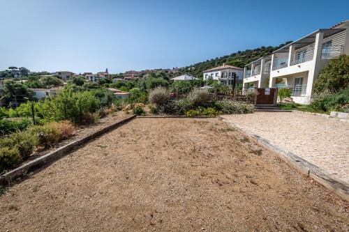 a large yard with plants and a house at Résidence U Manellu in Santa-Reparata-di-Balagna