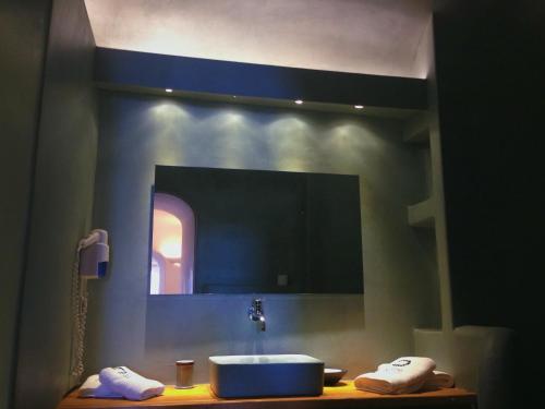 a bathroom with a sink and a mirror at Altana Cliffside Villas in Imerovigli
