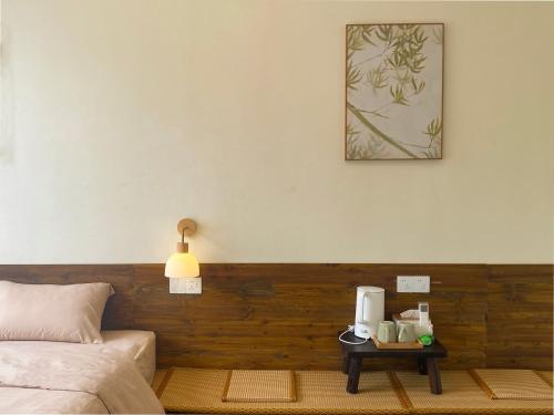 ein Schlafzimmer mit einem Bett und einem Tisch mit einer Kaffeemaschine in der Unterkunft Pomelo Hostel Xingping in Yangshuo