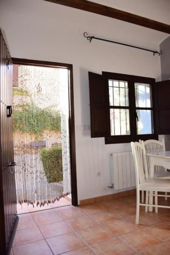 a room with a table and chairs and a sliding glass door at Oasis rural in Los Pastores