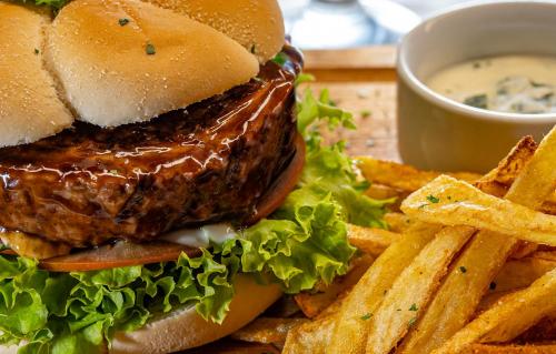 a hamburger and french fries with a cup of dipping sauce at Calvinia Hotel in Calvinia