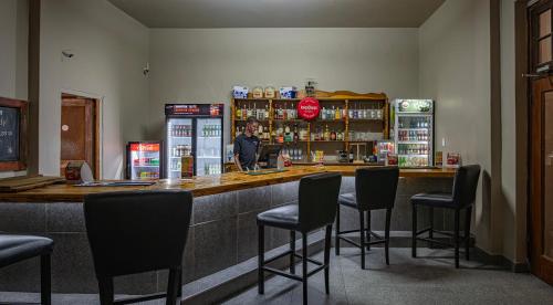 a bar in a restaurant with black bar stools at Calvinia Hotel in Calvinia