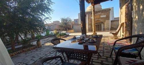 a patio with a table and chairs on a brick patio at B&B, Khiva ,, Abdullah " in ichan Kala in Khiva