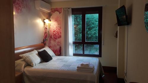 a small bedroom with a bed and a window at EL ENLACE in Elgóibar