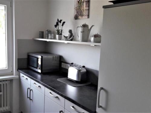 La cocina está equipada con tostadora y microondas. en Ferienwohnung Prior, en Bad Emstal