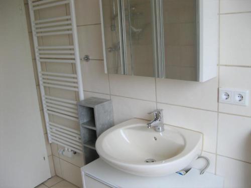 Baño blanco con lavabo y espejo en Ferienwohnung Prior, en Bad Emstal