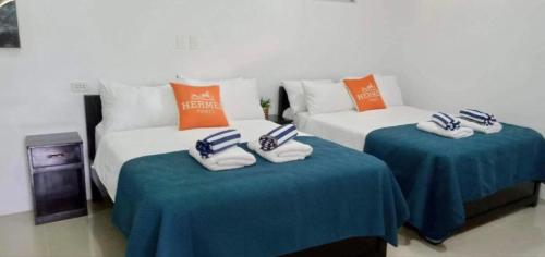 a room with two beds with blue and orange pillows at Lopez Beach Resort in Sipalay